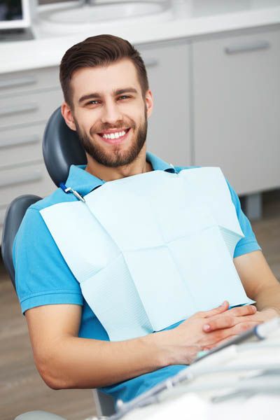 patient smiling during his dental appointment at Smile Design Center