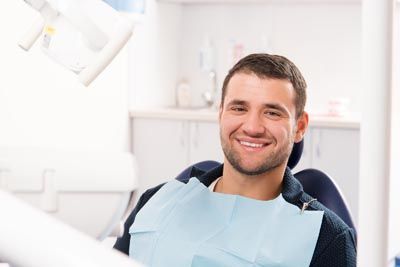 patient smiling after getting his teeth cleaned at Smile Design Center